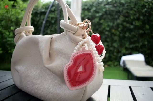 Kus met parels bag charm aan een tas