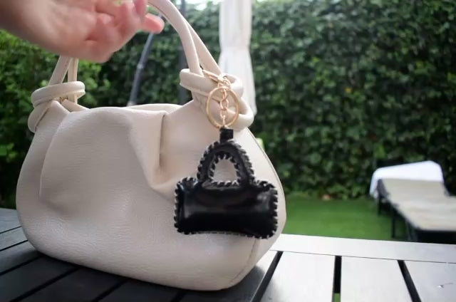 Mini tasje bag charm zwart aan een tas