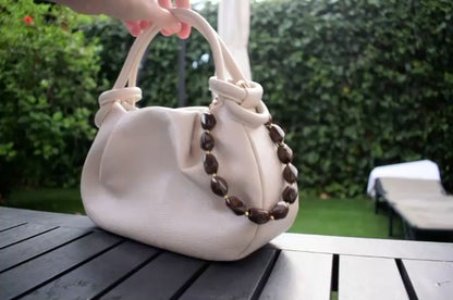 Kralen bag chain bruin aan een tas