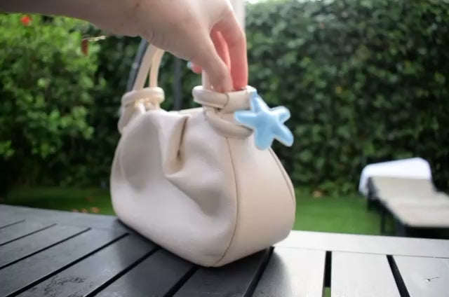 Ster van stof bag charm lichtblauw aan een tas