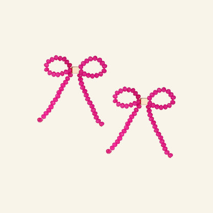 Strik oorbellen strass – roze, vrijstaand op beige